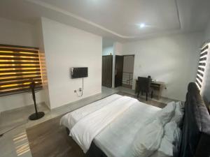sypialnia z dużym łóżkiem i biurkiem w obiekcie CHRIS SPORSHE w mieście Abudża