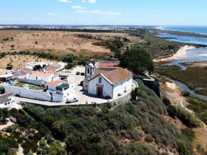 an aerial view of a house on a hill next to the ocean at NEW!! 1 Bedroom Vila Nova de Cacela in Vila Nova de Cacela