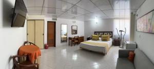 a bedroom with a bed and a living room at Hotel Sulicam in Neiva