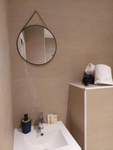 a bathroom with a sink and a mirror on the wall at Hôtel Ô9 marches in Rillieux