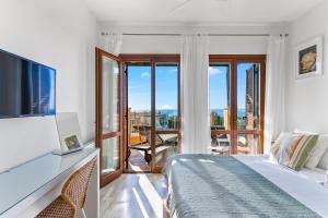 2 bedroom Apartment Thalassa with sea and sunset views, Aphrodite Hills Resort في كوكليا: غرفة نوم بسرير وشرفة