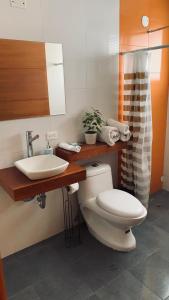 a bathroom with a toilet and a sink at Apricot Hosteria in Quito