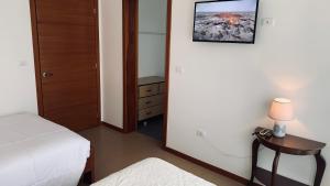 1 dormitorio con 1 cama y 1 mesa con lámpara en Apricot Hosteria, en Quito