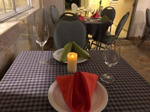 a table with two plates and a candle and glasses at Apricot Hosteria in Quito
