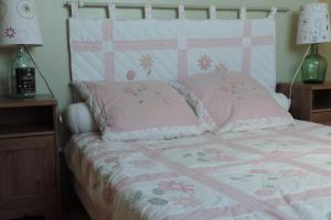 a bed with pink sheets and pink pillows at Maison 6 personnes vue mer in Plougrescant