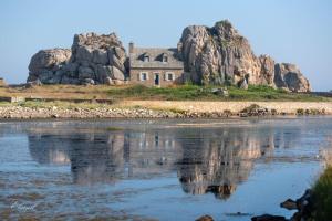 an old house on an island in the water at Maison 6 personnes vue mer in Plougrescant