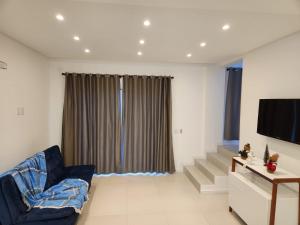 a living room with a couch and a television at Recanto Brisa e Mar in Palhoça
