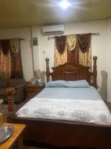 sypialnia z drewnianym łóżkiem i kanapą w obiekcie BMB Apartment w mieście Georgetown