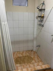 a bathroom with a shower and a tile floor at BMB Apartment in Georgetown