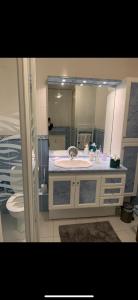 uma casa de banho com um lavatório, um WC e um espelho. em Appartement de standing vue mer 63 m2 em Trouville-sur-Mer