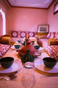 una mesa larga con tazones y platos en ella en RIAD LAICHI en Marrakech