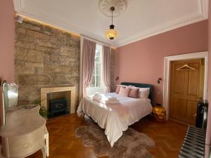 a bedroom with a large bed and a fireplace at Ashton View in Glasgow
