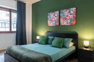 een slaapkamer met een bed met drie schilderijen aan de muur bij Home Principe Amedeo 184 in Bari