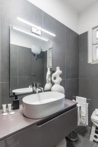 een badkamer met een groot wit bad en een spiegel bij Home Principe Amedeo 184 in Bari