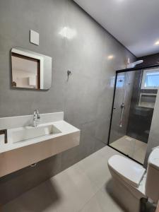 a bathroom with a toilet and a sink and a shower at Recanto Brisa e Mar in Palhoça
