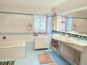 y baño con 2 lavabos, bañera y espejo. en Taferne in Köstendorf - Ferienwohnung Monteurzimmer, en Neumarkt am Wallersee
