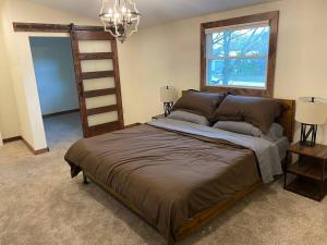 Cama grande en habitación con ventana en The Freedom House by Patriot Properties en Wisconsin Dells