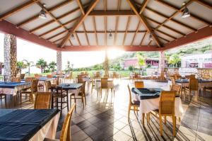 comedor con mesas y sillas y puesta de sol en HOTIDAY Resort San Nicola, en San Nicola Arcella