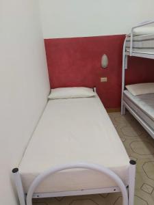 羅迪－加爾加尼科的住宿－case vacanze Rodi Garganico，配有两张双层床的客房内的一张白色床