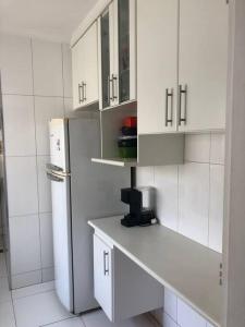 a kitchen with white cabinets and a refrigerator at Apartamento completo, com excelente localização in Americana