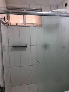 a glass shower in a bathroom with a window at Apartamento completo, com excelente localização in Americana