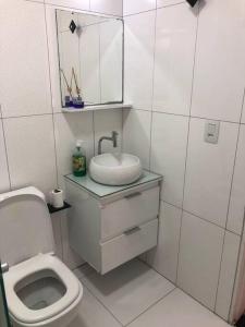 a white bathroom with a sink and a toilet at Apartamento completo, com excelente localização in Americana