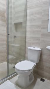 uma casa de banho com um WC e uma cabina de duche em vidro. em Hotel Mirador Gastro Bar em Chinú