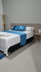 1 dormitorio con 1 cama con almohadas azules y blancas en Hotel Mirador Gastro Bar en Chinú
