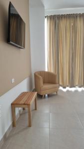 uma sala de estar com uma cadeira, uma mesa e uma televisão em Hotel Mirador Gastro Bar em Chinú