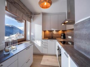 eine Küche mit weißen Schränken und einem großen Fenster in der Unterkunft Ferienwohnung Lentner in Maurach