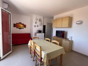 a kitchen and dining room with a table and a red couch at Casa vacanze Kastalia - Rossa in Ragusa