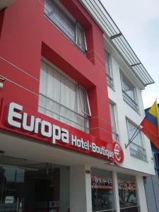 ein rotes Gebäude mit einem großen Hotelgebäude in der Unterkunft Europa Hotel Boutique Manizales in Manizales