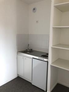 a small white kitchen with a sink and shelves at Aladin resort in Bouconvillers