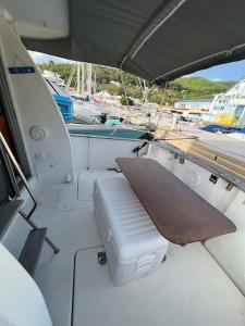 a boat with a bench in the back of it at Bateau double cabine proche de la plage in Gourbeyre