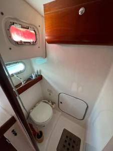 Bateau double cabine proche de la plage في Gourbeyre: حمام صغير مع مرحاض ونافذة