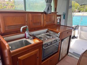 a kitchen with a sink and a stove at Bateau double cabine proche de la plage in Gourbeyre