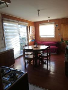 y cocina con mesa, sillas y fogones. en Departamento 4 personas central, en Viña del Mar