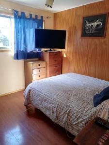 a bedroom with a bed and a flat screen tv at Departamento 4 personas central in Viña del Mar