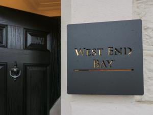 a sign that reads west end bay next to a door at West End Bay in Morecambe