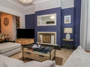 een woonkamer met blauwe muren en een open haard bij West End Bay in Morecambe