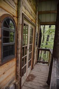 Maine Woods Treehouse-The Birdie في North Lovell: مدخل إلى كابينة خشب فيها باب ونوافذ