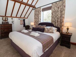 sypialnia z dużym łóżkiem i oknem w obiekcie Old Roost Farmhouse w mieście York