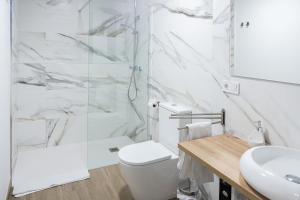 a bathroom with a shower and a toilet and a sink at Victoria Inn Apartment in Valencia