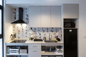 a kitchen with white cabinets and a black refrigerator at Victoria Inn Apartment in Valencia