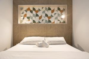 a bed with two white towels on top of it at Victoria Inn Apartment in Valencia
