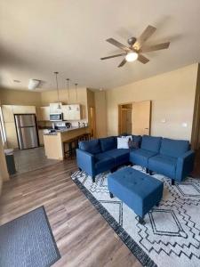 sala de estar con sofás azules y cocina en Cannery Square Unit - 106 by Patriot Properties, en Sun Prairie
