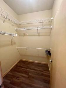 vestidor con estanterías y suelo de madera en Cannery Square Unit - 106 by Patriot Properties, en Sun Prairie