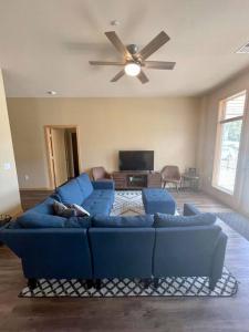 sala de estar con sofá azul y ventilador de techo en Cannery Square Unit - 106 by Patriot Properties, en Sun Prairie