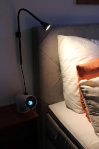 a lamp sitting on a night stand next to a bed at penthouse-studio centrally located in Zurich in Zurich