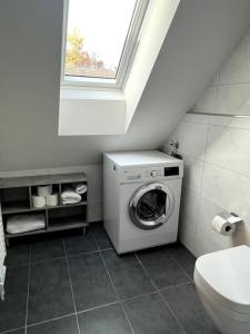ein Bad mit einer Waschmaschine und einem Fenster in der Unterkunft penthouse-studio centrally located in Zurich in Zürich